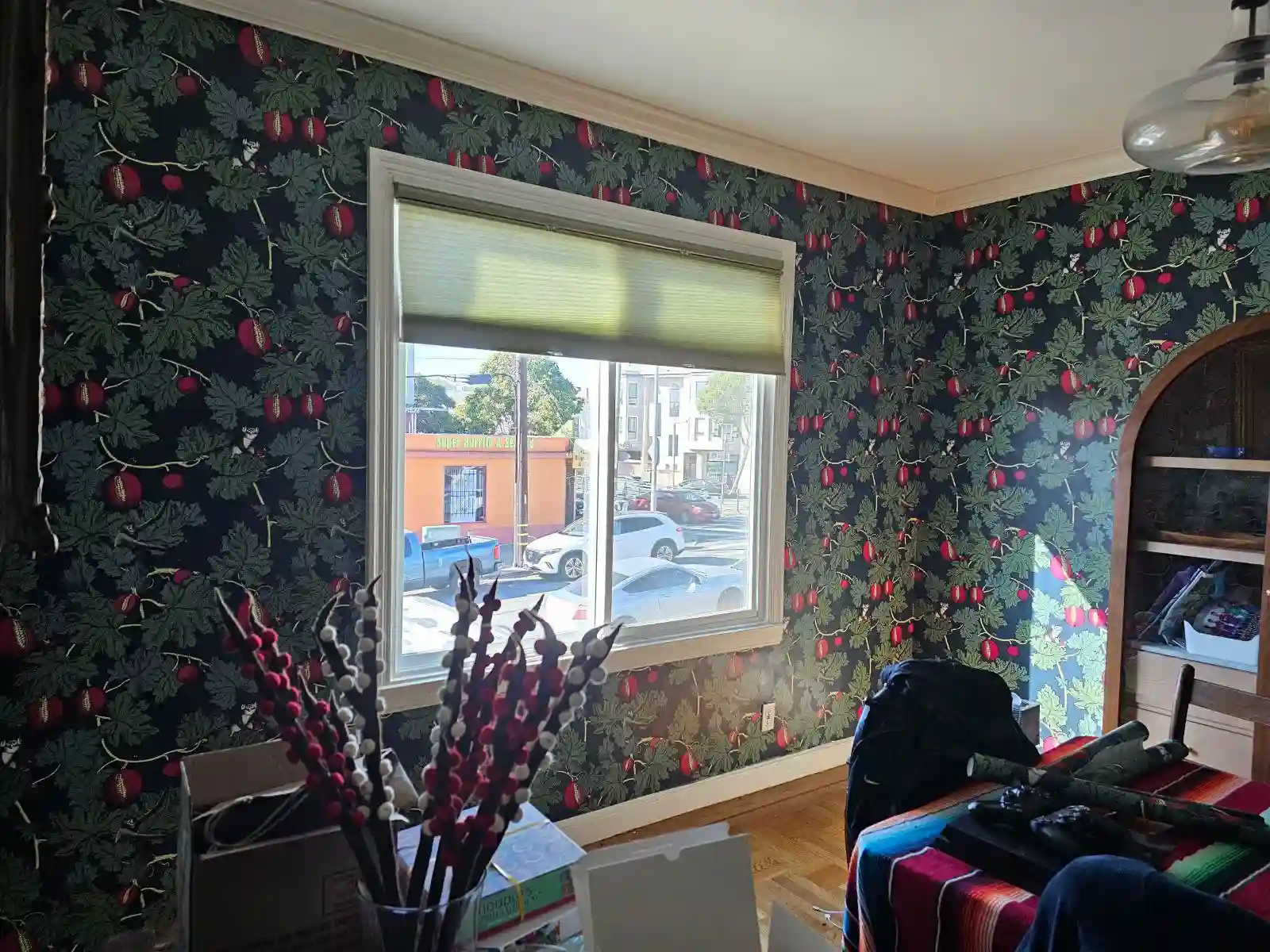 Dark botanical wallpaper with small berry motifs around a window